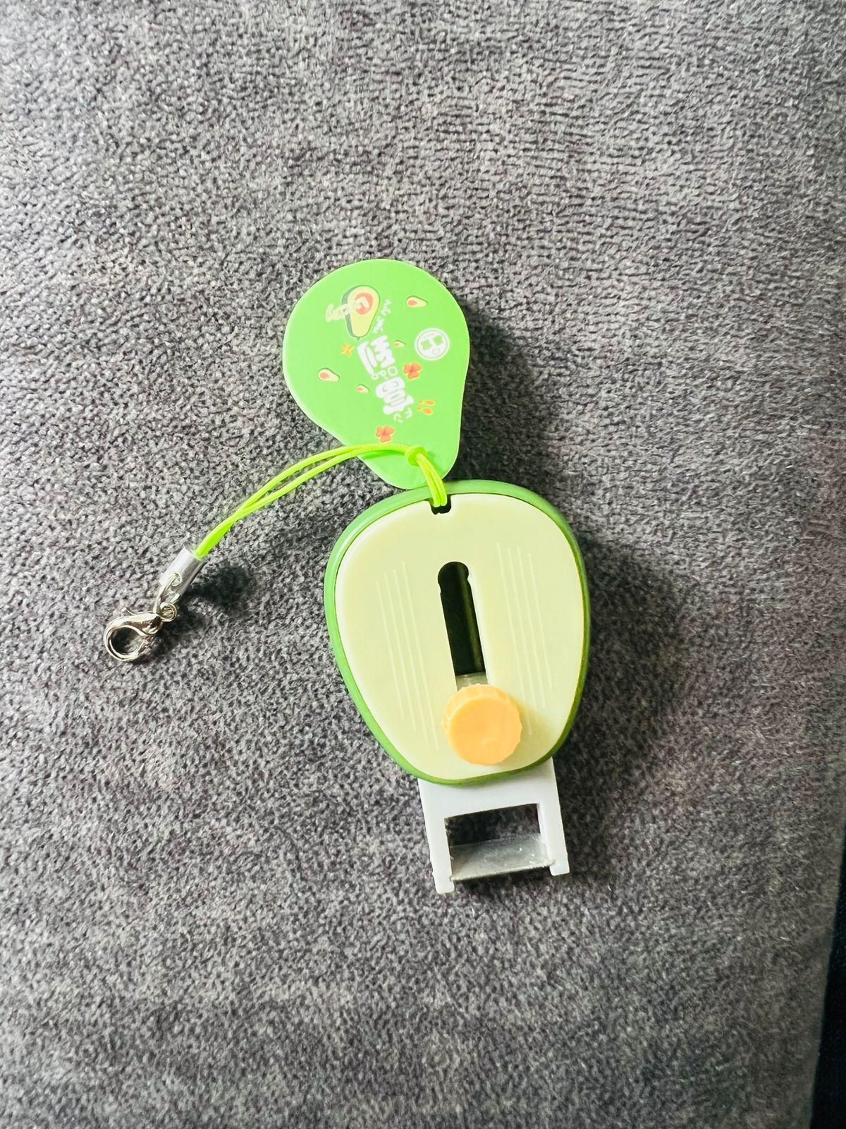 Green keychain with a small pouch on a gray surface