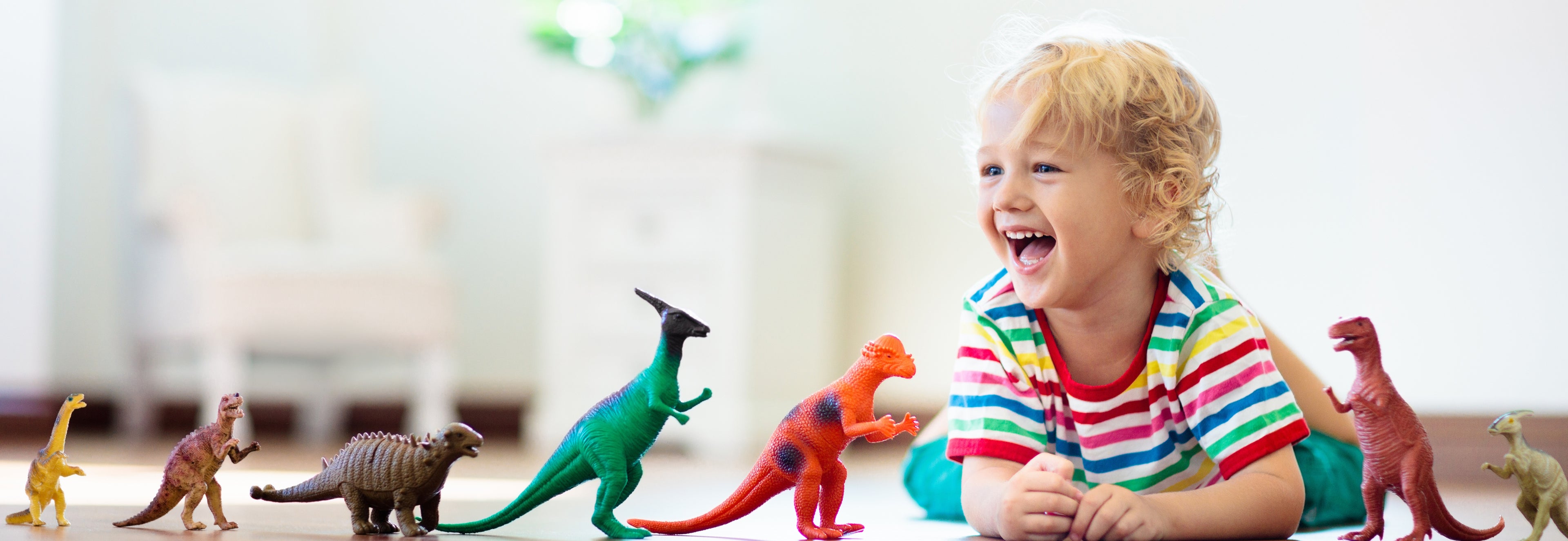 Child playing with dinosaur toys in a bright room