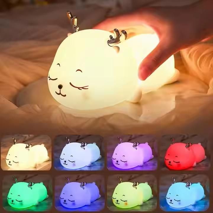 Cute animal-shaped night light with color-changing options on a soft surface.