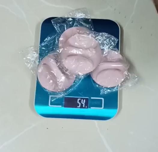 Pink rubber duckies on a digital scale with a white background