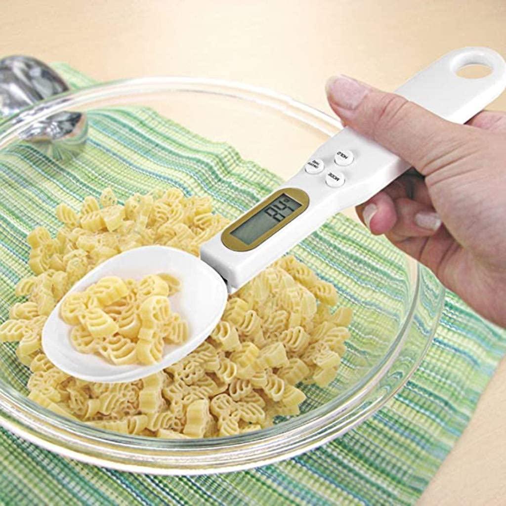 Digital measuring spoon with pasta in a glass bowl on a green and white striped cloth.