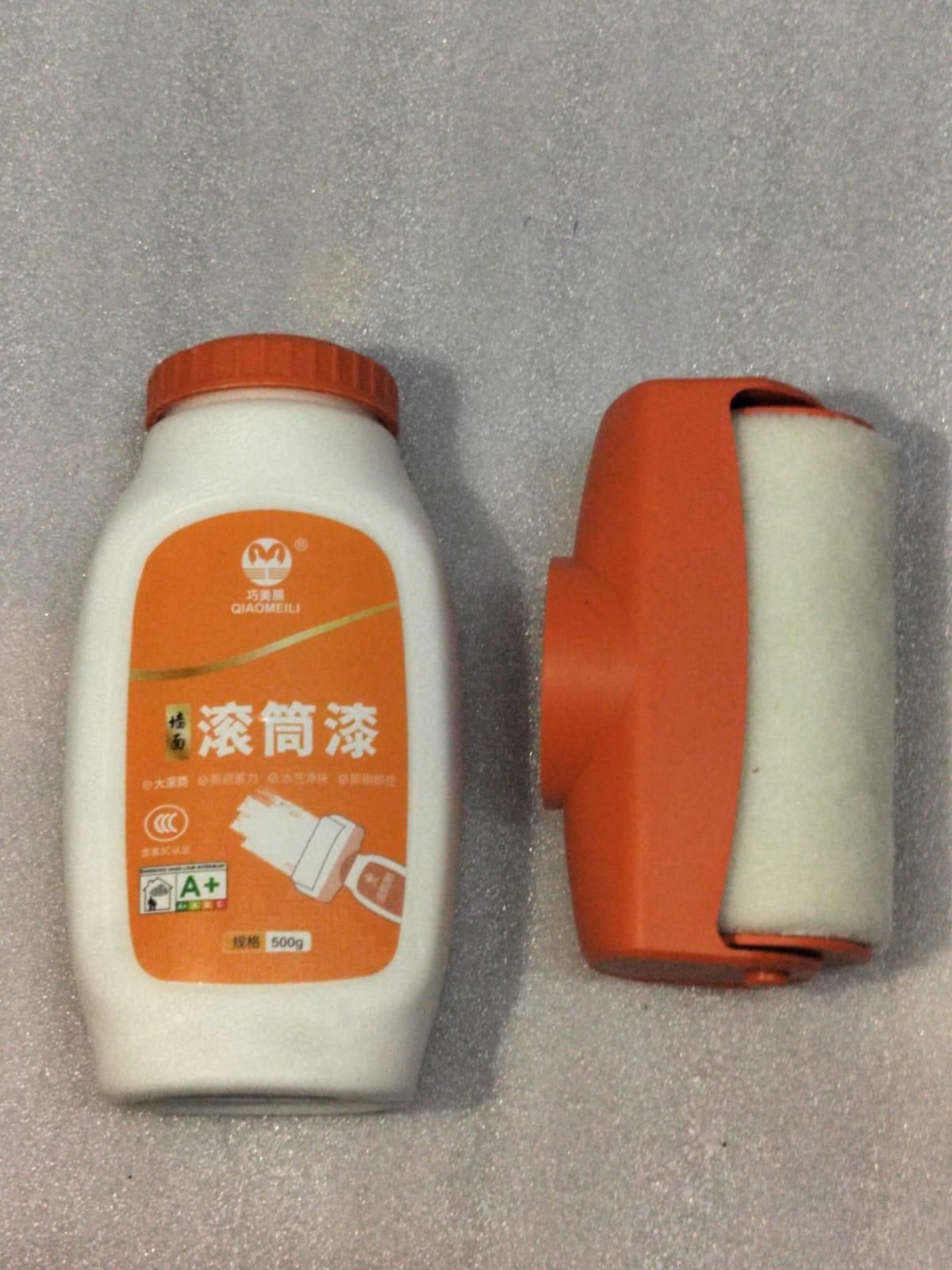 Paint roller and container on a gray background