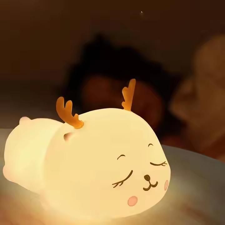 Cute lamp shaped like a cartoon deer with glowing face, blurred background