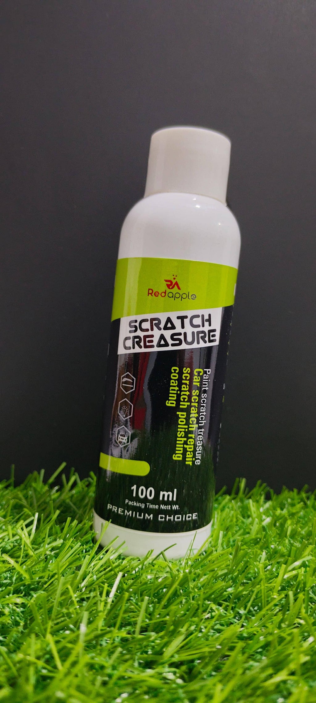 Bottle of 'Scratch Creasure' on grass with a dark background