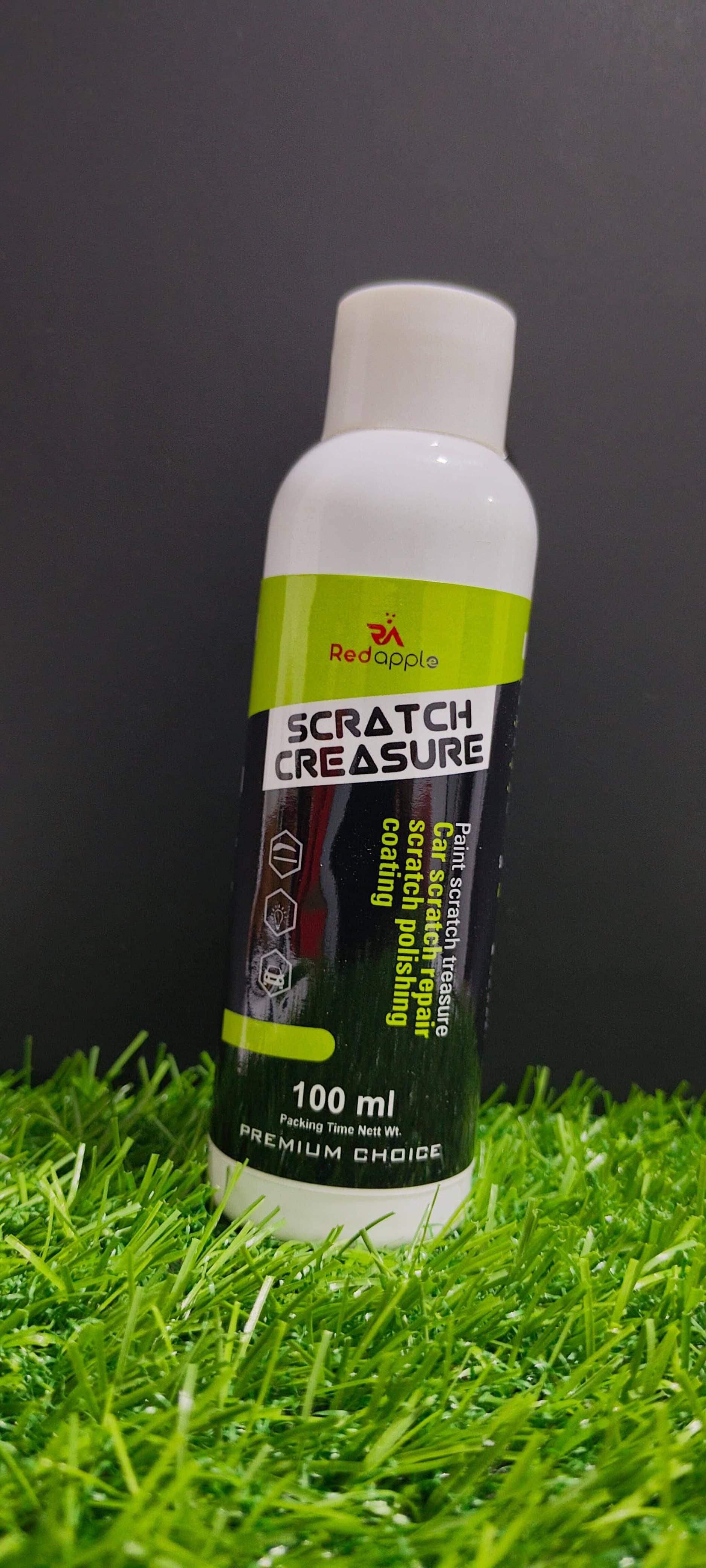 Bottle of 'Scratch Creasure' on grass with a dark background