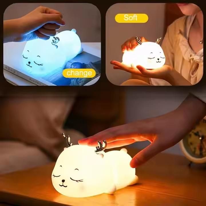Cat-shaped night light being held and placed on a surface by hands.