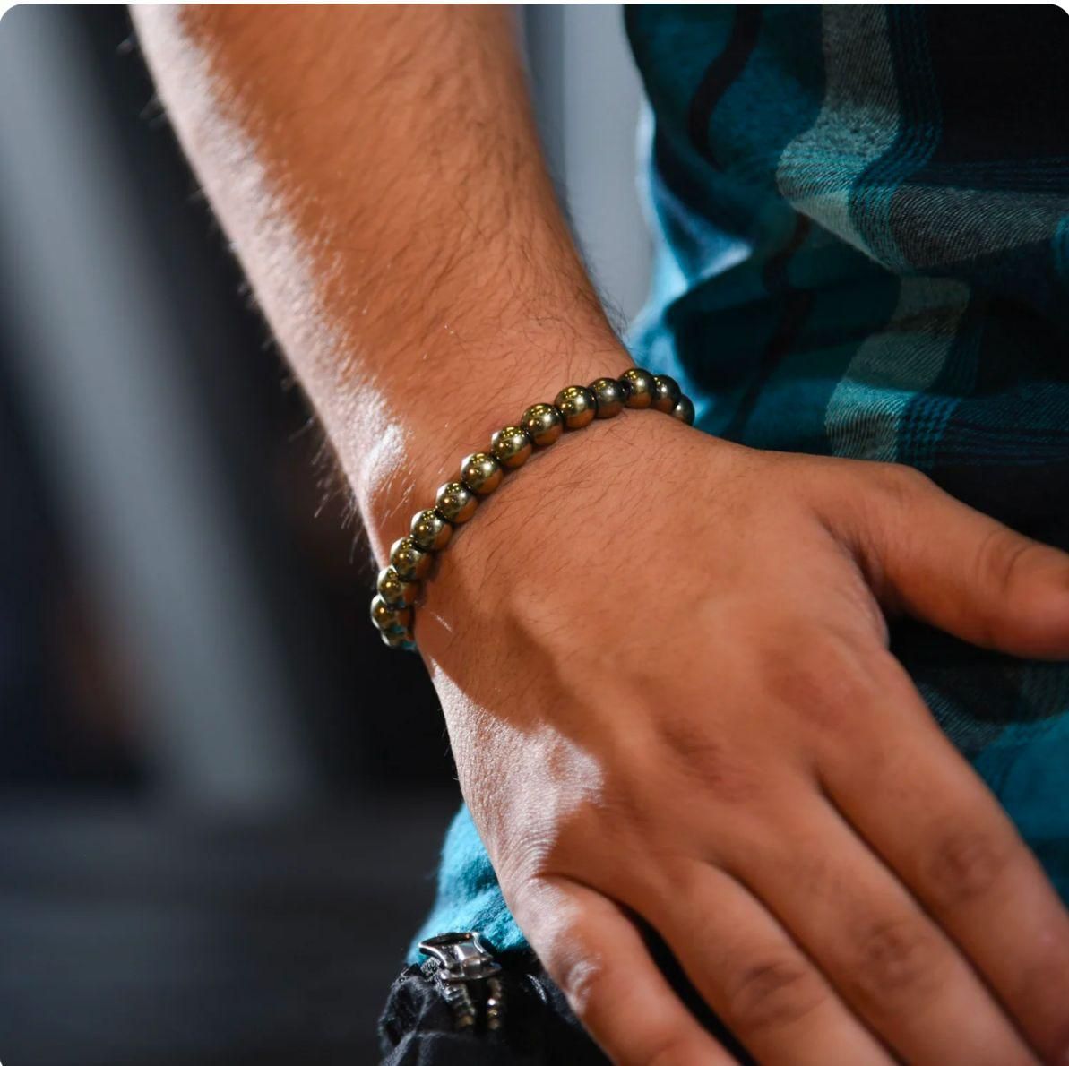 Close-up of a hand wearing a beaded bracelet with a blurred background