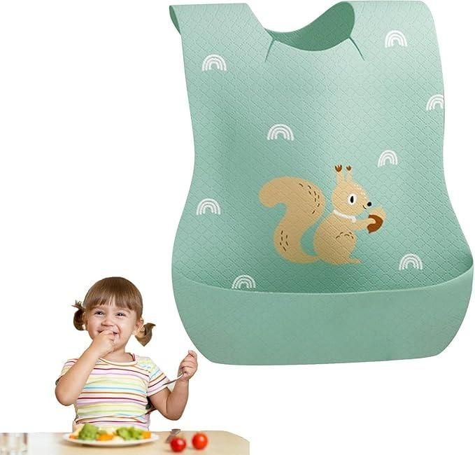 Children's bib with squirrel design on a green background, next to a child eating at a table.