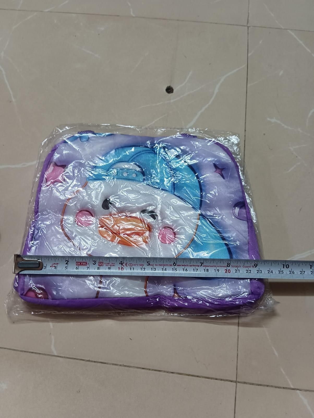 Children's play mat with cartoon design on a tiled floor, measured by a ruler.